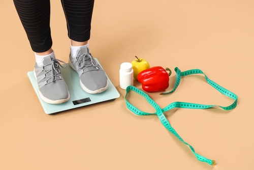 Woman,Standing,On,Scales,With,Pills,,Healthy,Food,And,Measuring